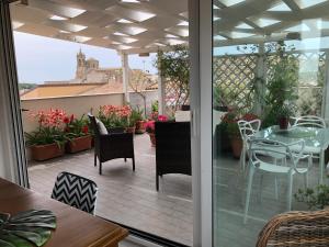 卡尔塔吉罗Attico Da Rosa con vista spettacolare a 360 gradi的露台的阳台配有桌椅