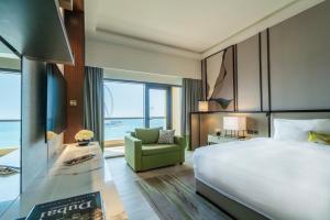迪拜安瓦吉罗塔纳朱梅拉海滩酒店-迪拜的酒店客房设有一张大床和一张绿色椅子。