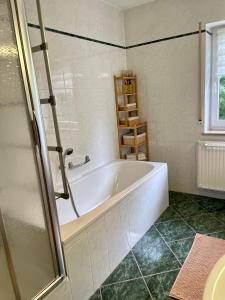 奥伯霍夫Visit_Oberhof_2的带窗户的浴室内的白色浴缸