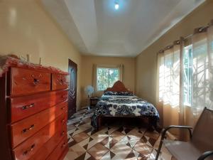 特雷热比奇Mango tree Oasis的一间卧室配有一张床、一个梳妆台和一扇窗户。