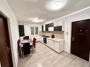 蒂米什瓦拉ADG 2 - Apartament cu 3 camere Timisoara的厨房配有桌子和红色椅子