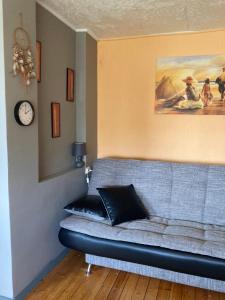 图库姆斯Studio tipa dzīvoklis的客厅的沙发,墙上有时钟