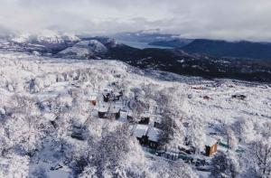 圣马丁德洛斯El Refugio Ski & Summer Lodge的天空中白雪覆盖的城镇景色
