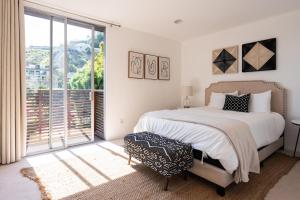 洛杉矶Urban Oasis: Stylish Mid-Century Home in Weho的一间卧室设有一张床和一个大窗户