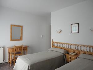 阿兰扎达布里萨酒店的一间卧室配有两张床、一张桌子和一面镜子