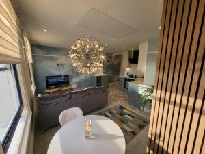 马盖特Sunset Point Apts - Blue Horizon Suite的客厅配有沙发和桌子