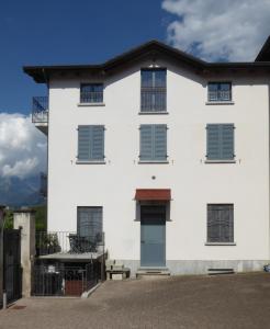 科利科Appartamento Bonita Vista的白色的建筑,设有蓝色的窗户和庭院