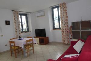 科利科Appartamento Bonita Vista的客厅配有桌子和红色沙发