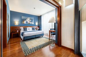 因佩里亚罗西尼阿堤亚托酒店的酒店客房,设有床铺和蓝色的墙壁