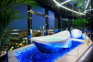 弗罗茨瓦夫Apartamenty Sky Tower z Wanna Przy Oknie的浴室设有蓝色岩石的台面上的浴缸