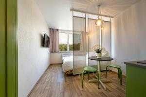 克莱佩达Berlin Studios的酒店客房带一张床、一张桌子和椅子