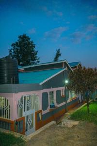 KisiiEntire Fully furnished Villas in Kisii的粉色白色的房子,前面有一棵树