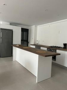 Ouled MoussaBel Appartement de standing的厨房配有白色橱柜和木制台面