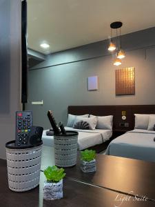 哥打京那巴鲁Relaxed Studio Q&S-Bed Near Airport WI-FI-Aeropod Sovo的酒店客房设有两张床和一张桌子。