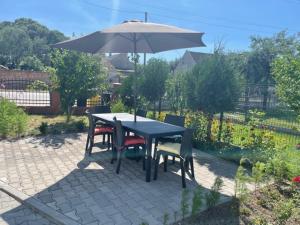 弗罗茨瓦夫Noclegi Budomas Klima-ParkigFree-SmartTv的庭院内桌椅和遮阳伞
