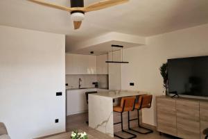 贝尼多姆Calasol - Moderno Apartamento en Cala de Finestrat的厨房配有吊扇和厨房岛