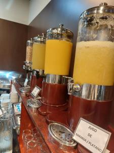 塔尔卡Hotel Diego de Almagro Talca Express的装有三罐橙汁的柜台