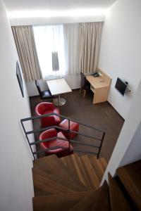 卢森堡2晚住宿公寓的酒店客房配有红色椅子和书桌