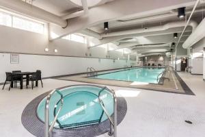 温哥华Heart of Downtown 1 bd - Pool, Gym, Parking, Office, AC的一座带桌子的大型游泳池