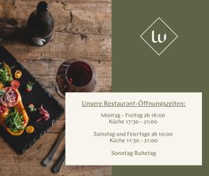 哈莱恩Langwies Genussherberge的一张桌子,上面放着一盘食物和一杯葡萄酒