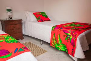 基布多Etnias Hotel tematico的一间卧室配有两张红色和绿色床单的床