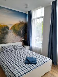 索波特Pokoje przy Plaży Sopot的一间卧室配有一张带铺着地毯的床和海滩壁画。