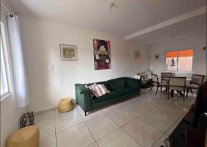瓜拉图巴Residencial Passos的客厅配有绿色沙发和桌子