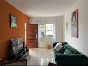 瓜拉图巴Residencial Passos的客厅设有绿色沙发和门。