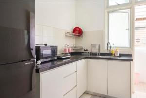 峇六拜Spice Arena Guesthouse的厨房配有白色橱柜和微波炉