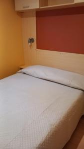 佩斯基奇Pozzo dei Desideri Appartamenti的卧室配有白色的床铺和红色的墙壁