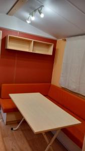 佩斯基奇Pozzo dei Desideri Appartamenti的红色墙壁的房间里,桌子和长凳