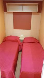 佩斯基奇Pozzo dei Desideri Appartamenti的小客房内的两张床,配有红色床单