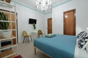 巴里L.T. BARI SUITE _ Locazioni Turistiche _的一间卧室配有蓝色的床和吊灯。