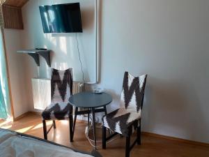 埃格尔Fiorita Vendégház的配有桌子和两把椅子以及电视的房间