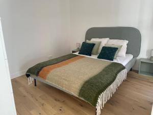 阿卡雄La Villa Mandarine sur Arcachon的一间卧室配有一张带绿色枕头的大床