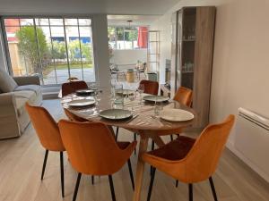 阿卡雄La Villa Mandarine sur Arcachon的一间带木桌和椅子的用餐室