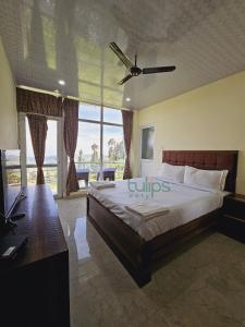 乌提Tulips Village Resorts的一间卧室配有一张大床和吊扇