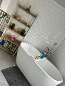 SirhowyTredegar property, unique location with luxury bedroom, bathroom & dining room的浴室铺有白色瓷砖,配有白色浴缸。