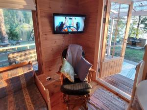 Lakeside Lea, rantamökki的门廊设有电视和椅子。