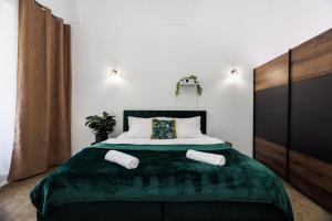 科希策SPAYA JACUZZI centrum apartment - with home cinema & private parking的一间卧室配有一张带绿毯的大床