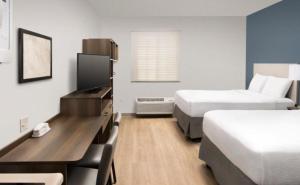 肯代尔WoodSpring Suites Miami Southwest的酒店客房配有两张床和一张书桌
