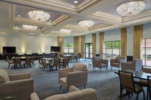 夏洛特夏洛特南方公园万豪酒店的大房间设有桌椅和吊灯
