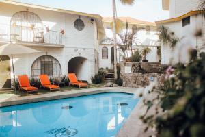 库埃纳瓦卡伊勒贝尔酒店的一座带橙色椅子的游泳池和一座建筑