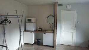 LehmjaGuesthouse near Tallinn的客房配有白色冰箱和带微波炉的桌子。
