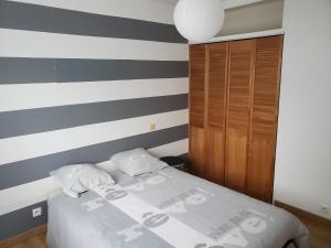 尼姆Orteils au soleil jardin parking的一间卧室配有一张床和条纹墙