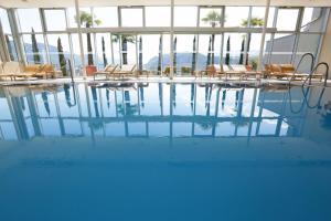 博尔扎诺福鹏伯尔扎诺伯泽喜来登酒店的大楼内一个带桌椅的游泳池