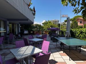 米兰马瑞提那Hotel Singapore的天井配有乒乓球桌和紫色椅子
