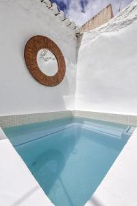 Canillas de AceitunoEncanto Guesthouse的一座白色建筑中的游泳池,设有圆形窗户