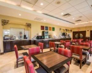 肯代尔迈阿密舒适套房酒店的餐厅设有木桌和红色椅子