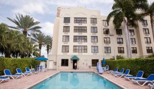 肯代尔迈阿密舒适套房酒店的一座带椅子的酒店、一座游泳池和一座建筑